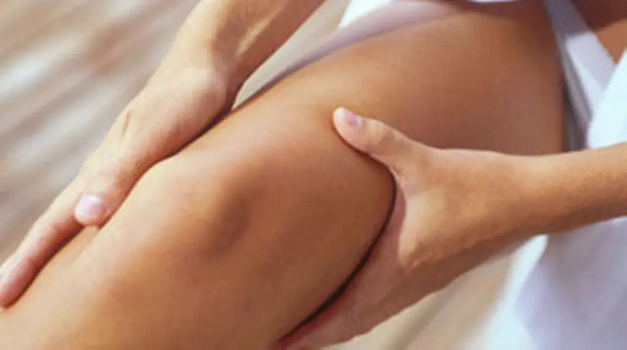 Hände massieren ein Knie, das sich trocken anfühlt.