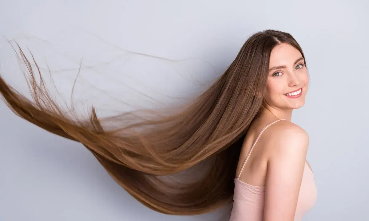 Frau mit langen, wallenden Haaren, die sich für gesunde Haare und um **Haare schneller wachsen lassen** interessiert.
