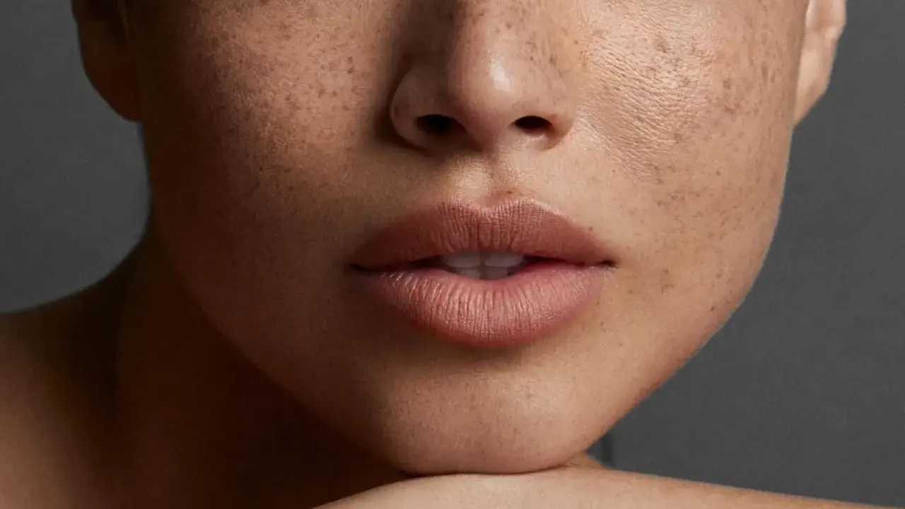 Nahaufnahme eines Gesichts mit Sommersprossen und perfekt geschminkten **Ombre Lippen**.