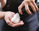 Schaumfestiger Anwendung: Eine Hand hält eine Flasche, aus der weißer Schaum in die andere Hand fließt.