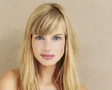 Blonde Frau mit blauen Augen und einem lässigen Pony, der aussieht, als hätte sie ihn selber geschnitten.