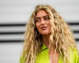Frauen mit voluminösen, welligen Haaren, die durch locken ohne hitze erzielt wurden. Sie trägt ein leuchtend grünes Hemd.