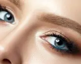 Nahaufnahme eines Gesichts, das die Augen betont. Blaue Augen strahlen lassen durch geschicktes Make-up mit braunen und blauen Akzenten.