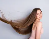 Frau mit langen, wallenden Haaren, die sich für gesunde Haare und um **Haare schneller wachsen lassen** interessiert.