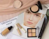 Make-up für ebenmäßige Haut: Foundation, Concealer, Puder und Konturpalette liegen bereit.