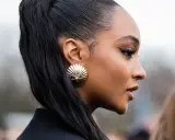 Ein scharfer Cat-Eye-Liner betont die Augen, perfekt aufgetragen mit Kajal. Goldene Muschel-Ohrringe und ein hoher Pferdeschwanz runden den Look ab.