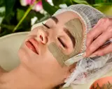 Eine Frau erhält eine Gesichtsmaske. Die heilerde-wirkung haut wird durch das Auftragen der Maske mit einem Pinsel gezeigt.