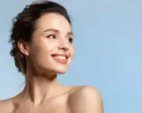 Strahlendes Lächeln einer Frau, die die positive Vitamin E Wirkung auf ihre Haut genießt.