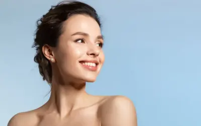 Strahlendes Lächeln einer Frau, die die positive Vitamin E Wirkung auf ihre Haut genießt.