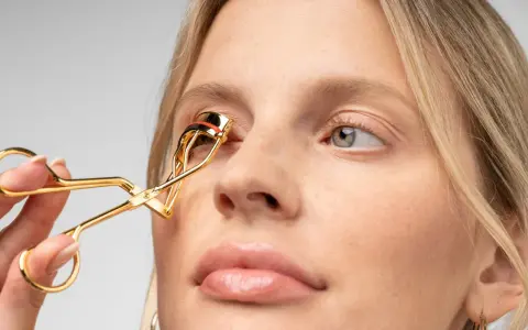 Goldene Wimpernzange wird benutzt, um den Wimpern Schwung zu geben. Ein Schritt für einen perfekten Augenaufschlag.
