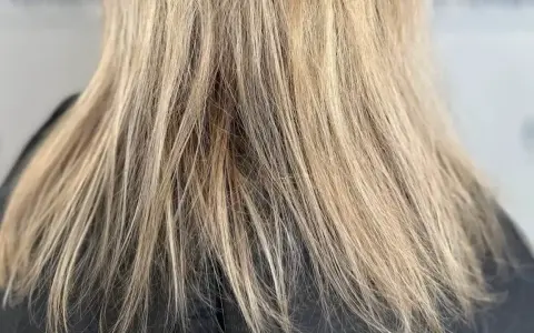 Nahaufnahme von schlecht blondierten Haaren mit deutlichen Strähnen und ungleichmäßiger Farbe.
