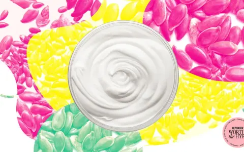 Cremige Textur einer leinsamen maske gesicht, umgeben von bunten Leinsamen in Pink, Gelb und Grün.
