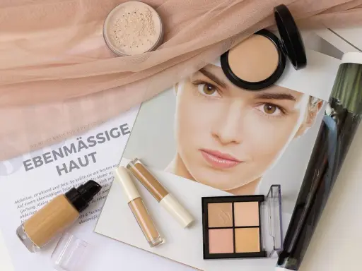 Make-up für ebenmäßige Haut: Foundation, Concealer, Puder und Konturpalette liegen bereit.