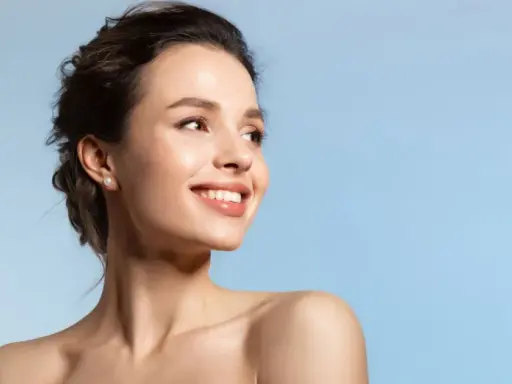 Strahlendes Lächeln einer Frau, die die positive Vitamin E Wirkung auf ihre Haut genießt.