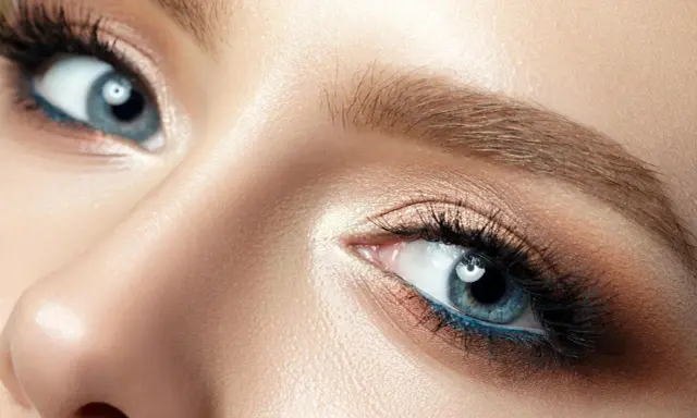 Nahaufnahme eines Gesichts, das die Augen betont. Blaue Augen strahlen lassen durch geschicktes Make-up mit braunen und blauen Akzenten.