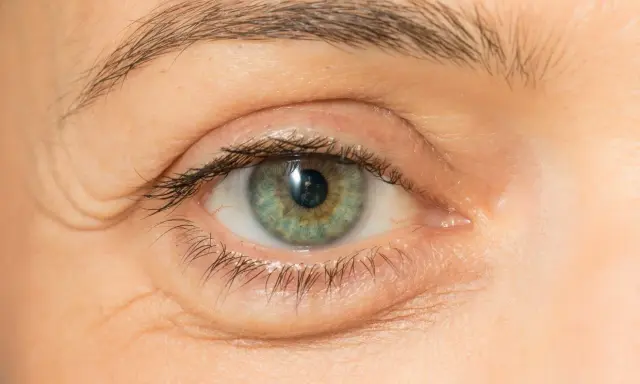 Nahaufnahme eines Auges mit knittriger Haut unter den Augen. Suche nach Hausmittel gegen Falten.