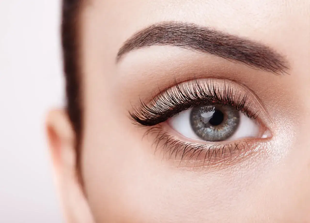 Ein makelloses Auge mit langen Wimpern und perfekt geschwungenen Brauen, das strahlende Augen schminken perfektioniert.