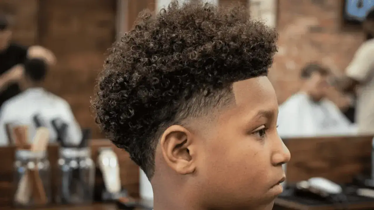 Junger Mann mit coolen locken haare, frisch vom Friseur.
