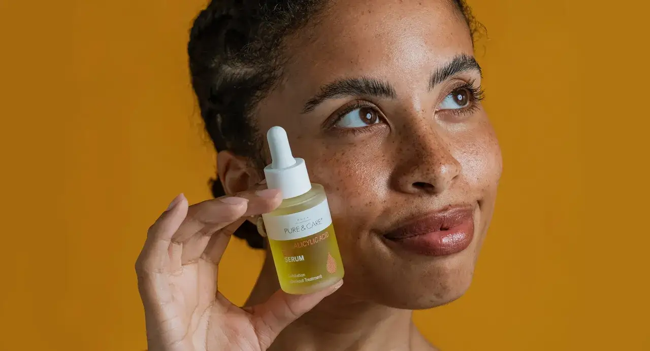 Eine Frau h&auml;lt ein Serum mit Salicyls&auml;ure. Die Inhaltsstoffe wie AHA, BHA und PHA helfen bei der Hautpflege.