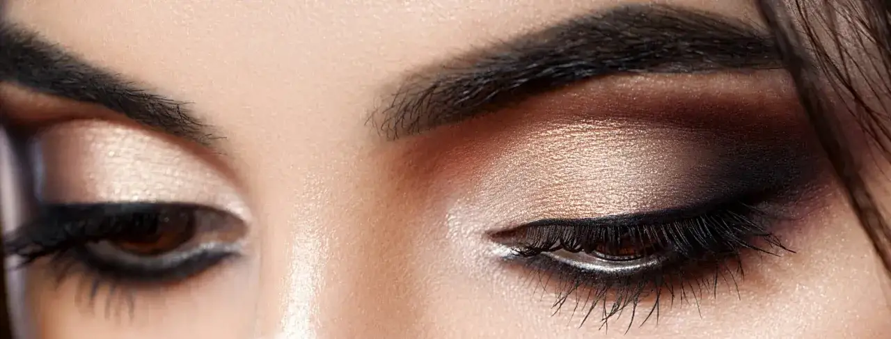 Glamouröses Augen Make-up für die Hochzeit: Goldener Lidschatten, schwarzer Eyeliner und volle Wimpern.