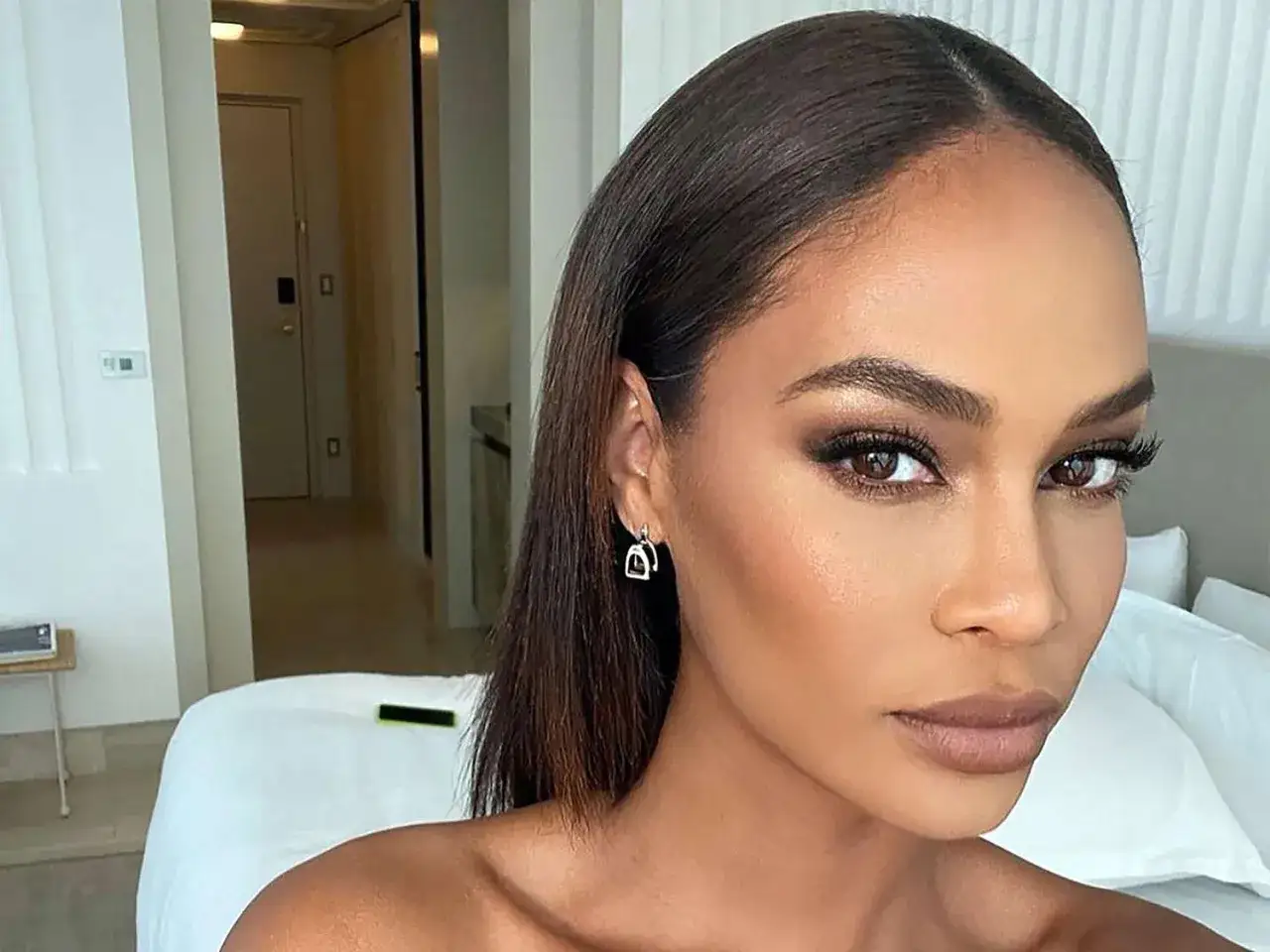 Eine Frau mit perfektioniertem Make-up, die zeigt, wie man bronzer auftragen kann, um Konturen zu betonen.