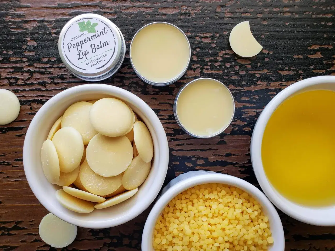 Zutaten für selbstgemachten Lippenbalsam: Kakaobutter, Bienenwachs, Öl und fertige Lippenbalsam-Tiegel.